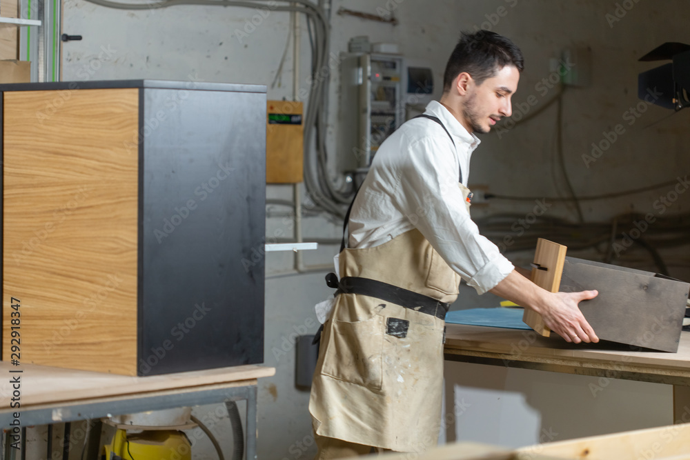 Furniture factory and small and medium sized enterprises concept - Man collects furniture details Furniture factory and small and medium sized enterprises concept - Man collects furniture details