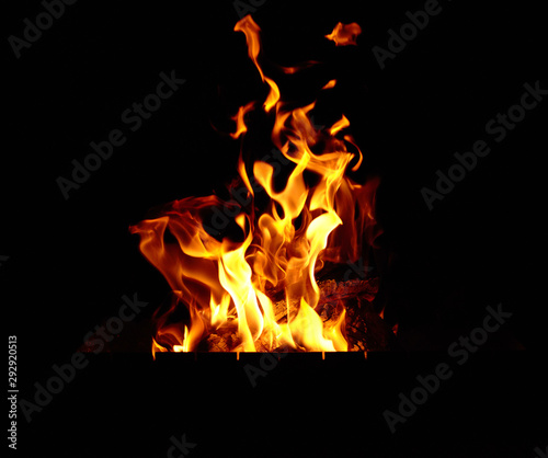 burning bonfire with logs and large orange flames at night