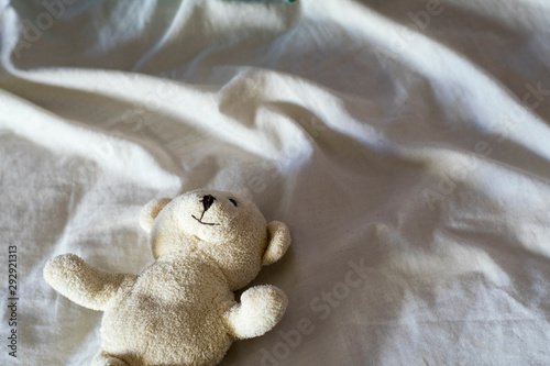 white teddy bear in bed © miriamgilalbert