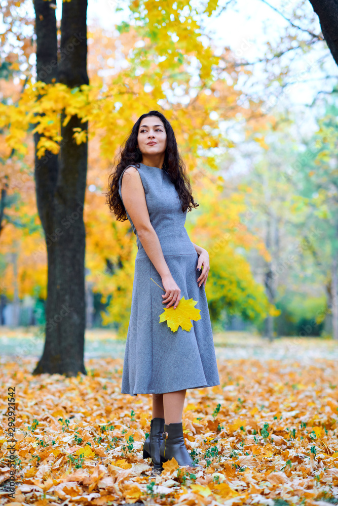 woman posing with autumn leaves in city park, outdoor portrait woman posing with autumn leaves in city park, outdoor portrait