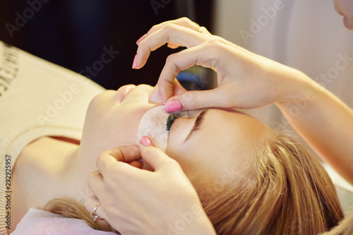 beautician making artificial lashes. eyelash extension procedure. © bakharev