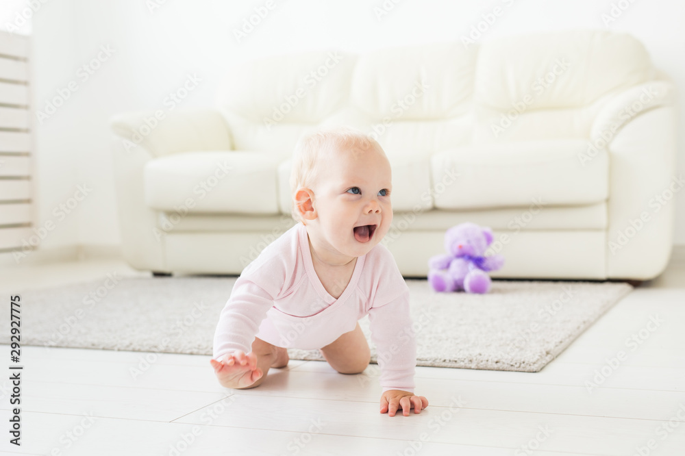 Portrait of a cute baby crawling and laughing on the floor at home Portrait of a cute baby crawling and laughing on the floor at home
