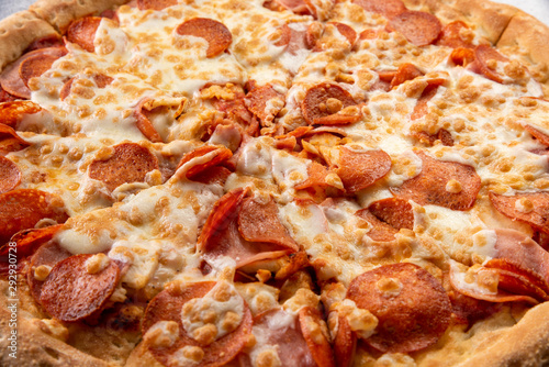 Delicious hot homemade Pepperoni pizza on the wooden table. Pepperoni Pizza - Fresh homemade pizza with pepperoni, cheese and tomato sauce on rustic black stone background with copy space.