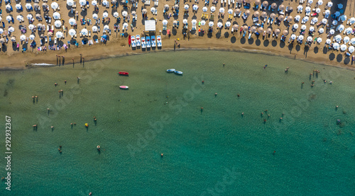 AERIAL. Summer beach with people and turquoise ocean water from top point of view,