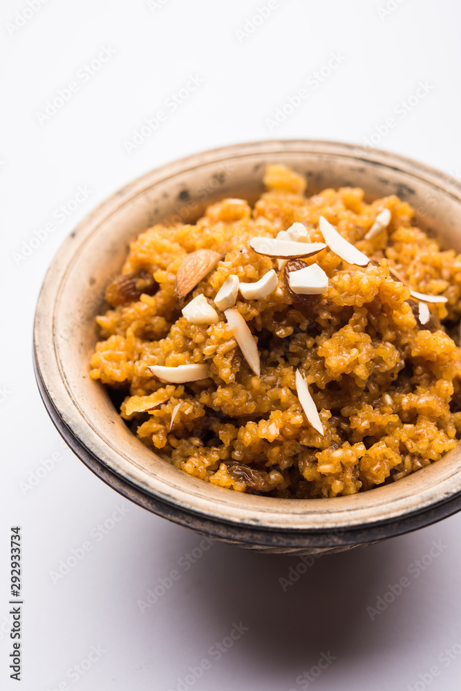 Wheat Laapsi/Lapsi/Shira/Halwa is an Indian sweet dish made of broken wheat or Daliya pieces and ghee along with nuts, raisins and dried fruits. It's a healthy food. served in a bowl, selective focus Wheat Laapsi/Lapsi/Shira/Halwa is an Indian sweet dish made of broken wheat or Daliya pieces and ghee along with nuts, raisins and dried fruits. It's a healthy food. served in a bowl, selective focus