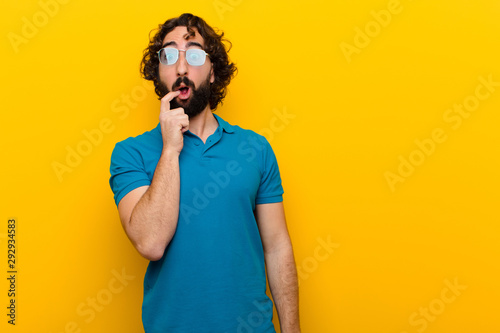 Canvas Print young crazy man with surprised, nervous, worried or frightened look, looking to