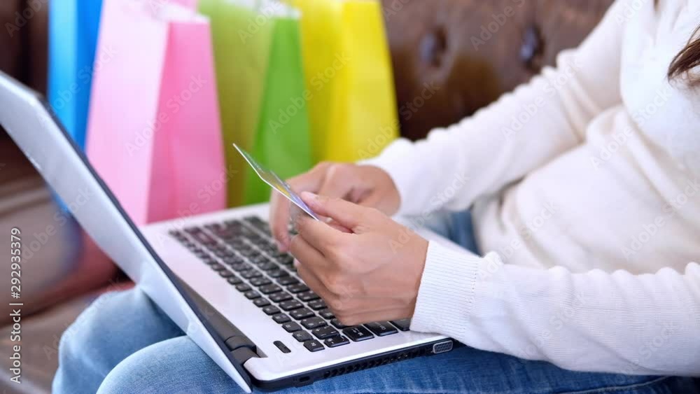 Young woman holding credit card and using laptop with shopping bag, Online payment concept Young woman holding credit card and using laptop with shopping bag, Online payment concept