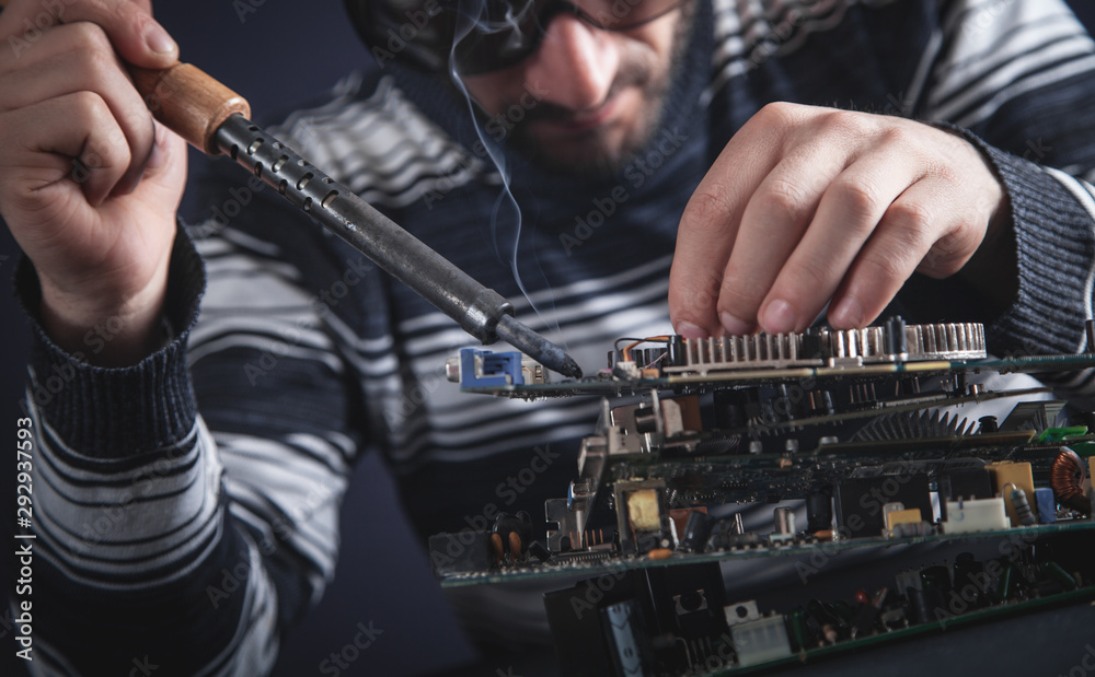 Computer hardware engineering. Engineer soldering computer motherboard Computer hardware engineering. Engineer soldering computer motherboard