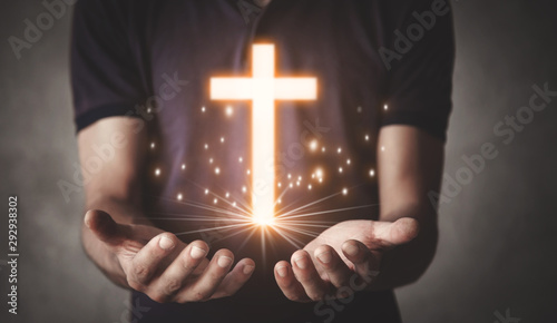 Caucasian man holding cross...