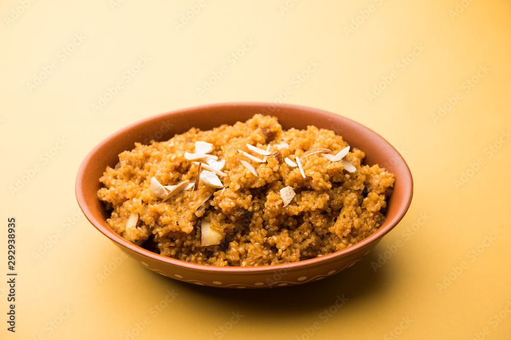 Wheat Laapsi/Lapsi/Shira/Halwa is an Indian sweet dish made of broken wheat or Daliya pieces and ghee along with nuts, raisins and dried fruits. It's a healthy food. served in a bowl, selective focus Wheat Laapsi/Lapsi/Shira/Halwa is an Indian sweet dish made of broken wheat or Daliya pieces and ghee along with nuts, raisins and dried fruits. It's a healthy food. served in a bowl, selective focus