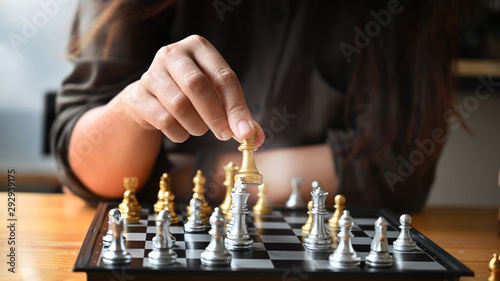 Cropped shot young woman paling chess board on table.