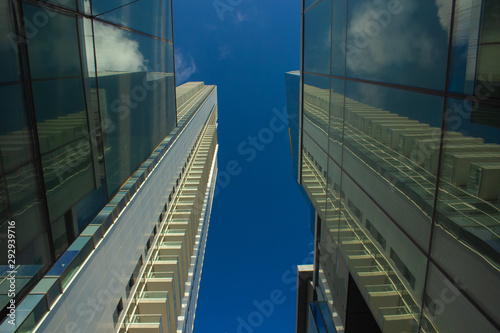 European skyscraper shopping mall glass exterior modern building city urban view from below on blue sky background 