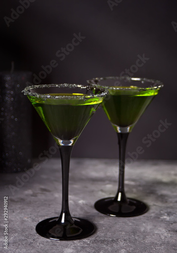 Two glasses with green zombie cocktail for Halloween party on the gray background