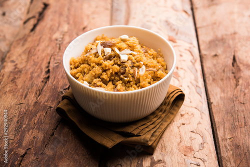 Wheat Laapsi/Lapsi/Shira/Halwa is an Indian sweet dish made of broken wheat or Daliya pieces and ghee along with nuts, raisins and dried fruits. It's a healthy food. served in a bowl, selective focus photo