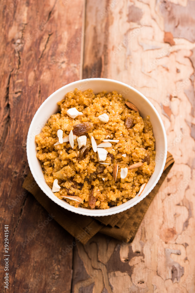 Wheat Laapsi/Lapsi/Shira/Halwa is an Indian sweet dish made of broken wheat or Daliya pieces and ghee along with nuts, raisins and dried fruits. It's a healthy food. served in a bowl, selective focus Wheat Laapsi/Lapsi/Shira/Halwa is an Indian sweet dish made of broken wheat or Daliya pieces and ghee along with nuts, raisins and dried fruits. It's a healthy food. served in a bowl, selective focus