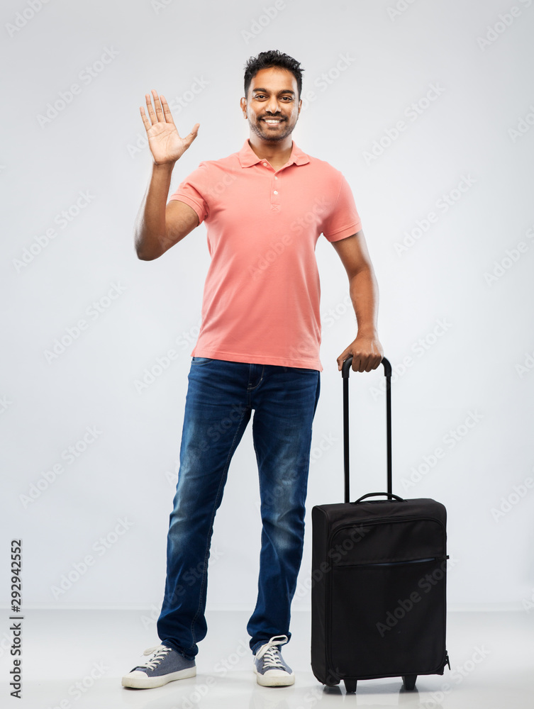 family, tourism and vacation concept - smiling indian man in polo shirt with travel bag waving hand over grey background family, tourism and vacation concept - smiling indian man in polo shirt with travel bag waving hand over grey background