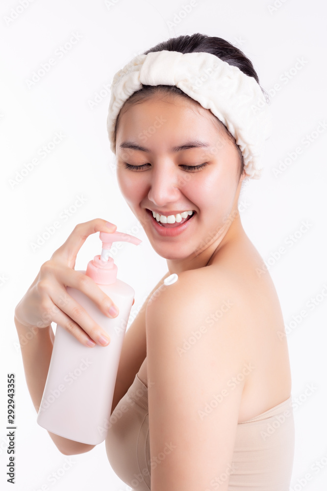 Beautiful young woman putting moisturizer body lotion to body, shoulder  after finish shower, smiley face. Attractive beautiful lady has nice skin,  her skin look younger than her age, body care concept Photos