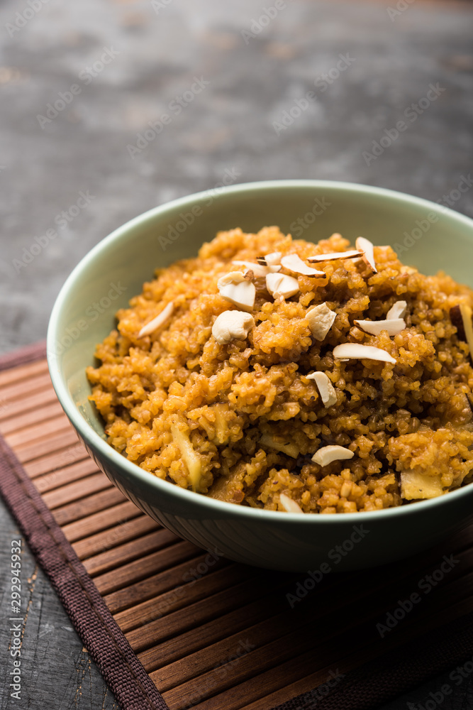 Wheat Laapsi/Lapsi/Shira/Halwa is an Indian sweet dish made of broken wheat or Daliya pieces and ghee along with nuts, raisins and dried fruits. It's a healthy food. served in a bowl, selective focus Wheat Laapsi/Lapsi/Shira/Halwa is an Indian sweet dish made of broken wheat or Daliya pieces and ghee along with nuts, raisins and dried fruits. It's a healthy food. served in a bowl, selective focus