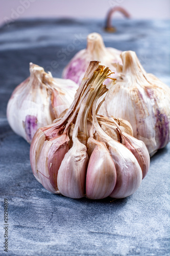 Whole violet garlic bulbs close up on grey marble plank