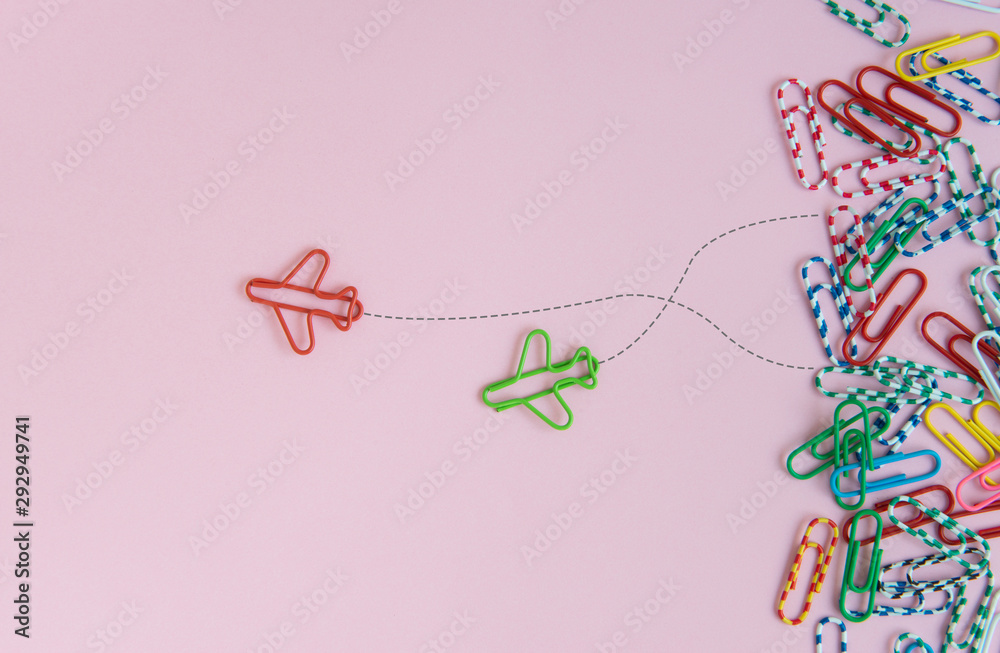 Business concept for group of stacked paperclip with another two red and green plane paperclip is point to another direction as a team leadership - obrazy, fototapety, plakaty 
