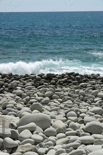 Beach with large stones near the Cinque Terre. Velvety sea with long exposure. Scoglio del Ferale, La Spezia.