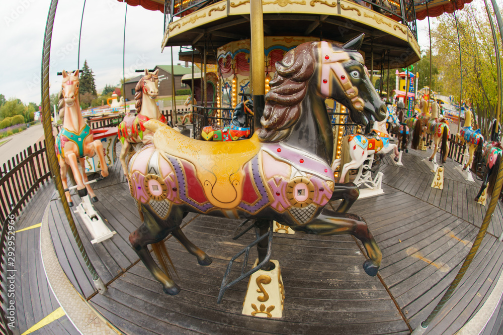 Riding around a horses carousel in autumn day