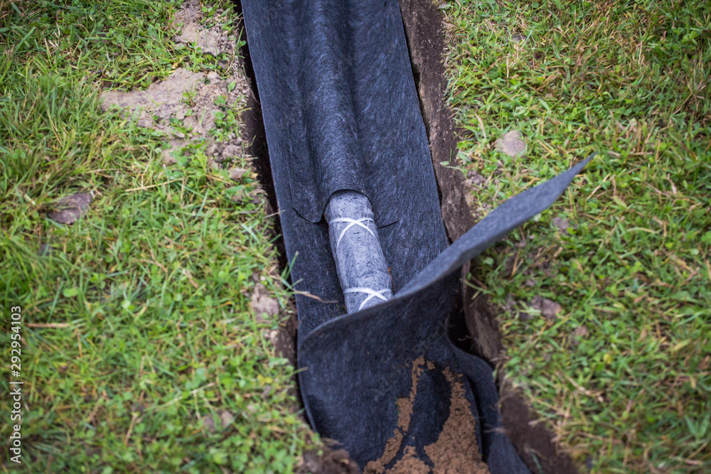 Drainage ditch. Laying a drainage pipe. Earthwork. Stock Photo Adobe