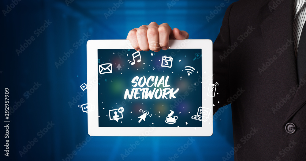 Young business person working on tablet and shows the inscription: SOCIAL NETWORK Young business person working on tablet and shows the inscription: SOCIAL NETWORK
