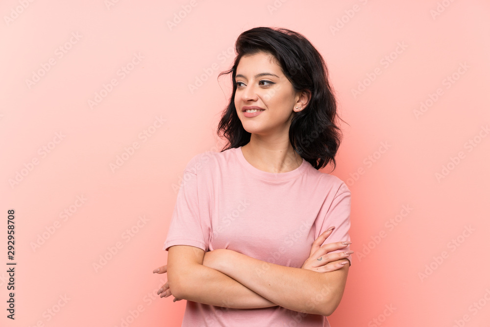 Fototapeta premium Young woman over isolated pink background looking to the side
