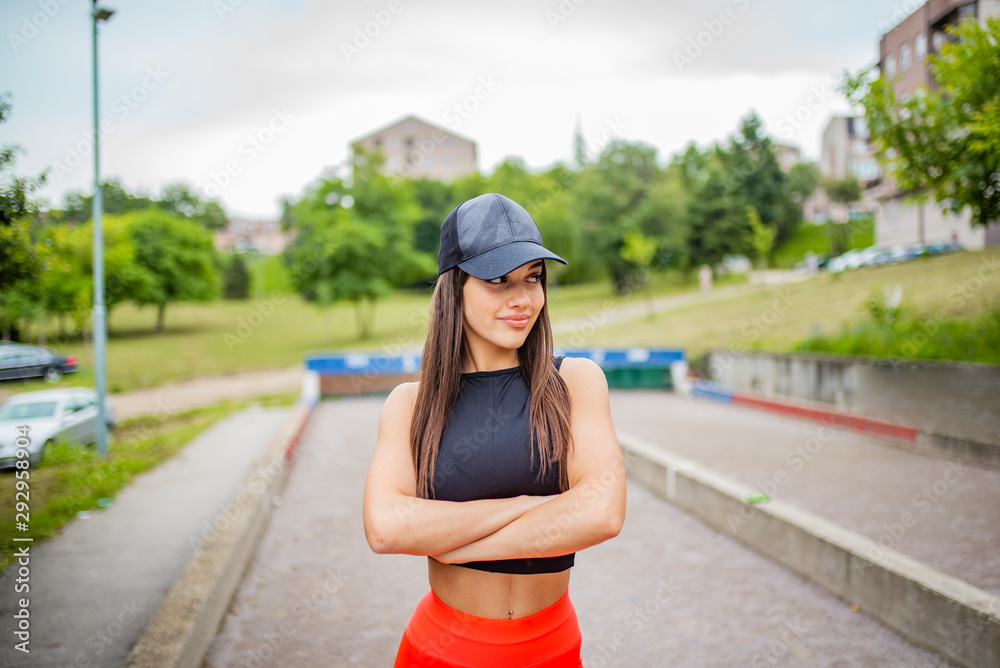 Portrait of fitness young woman outdoors in the city. Confident fitness model in park. Sportswoman resting. Portrait of happy fitness woman. A shot of a beautiful sporty caucasian woman outdoor