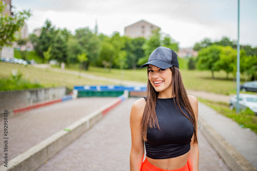 Fitness sport woman in fashion sportswear fitness exercise in the city street. A shot of a beautiful sporty caucasian woman outdoor. Fit brunette in the park on a sunny day