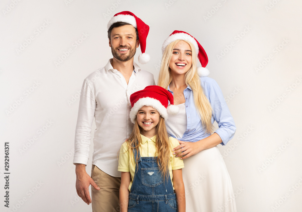 Family In Santa Hats Posing Over White, Christmas Background Family In Santa Hats Posing Over White, Christmas Background