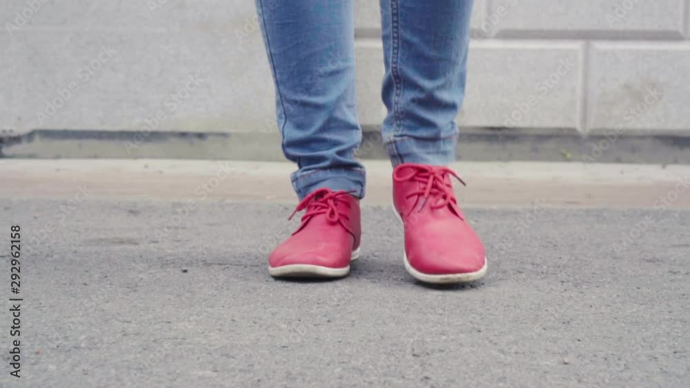 Woman is walking in city in daytime in autumn, close-up view of her red shoes, strolling Woman is walking in city in daytime in autumn, close-up view of her red shoes, strolling