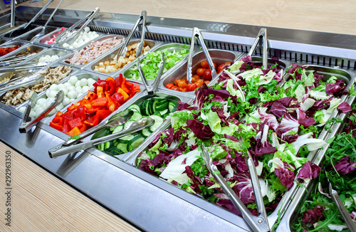 Fresh salad bar with various fresh assortment of ingredients. Display space of options for choice of clients in supermarket or restaurant photo