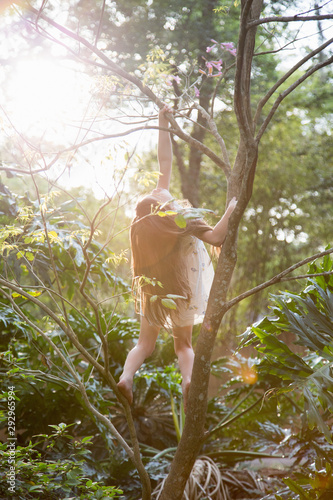 A little girl collecting easter eggs and climbing a tree