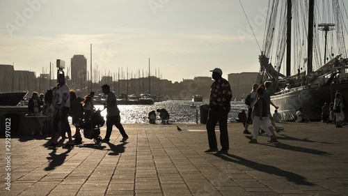 MARSEILLE, FRANCE - SEPTEMBER 28, 2019: At sunset people walk along the old port of Marseille, France