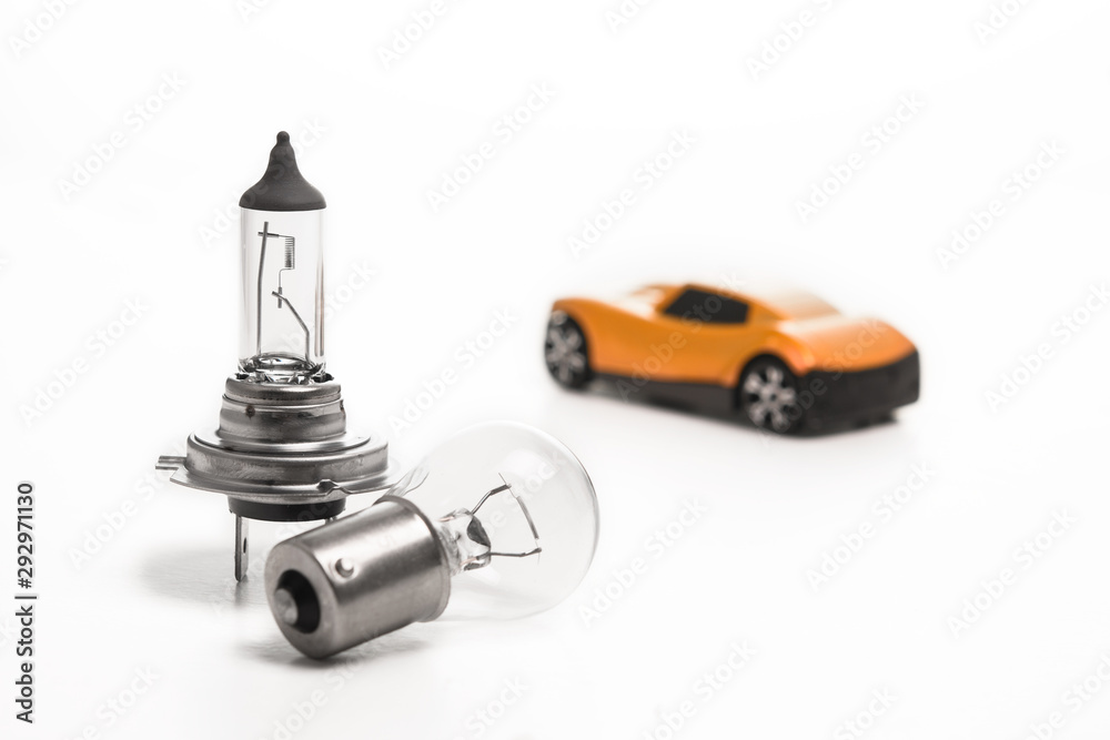 Car light bulb on a white background in front of a yellow car. Car lamps. The concept of service tinning a car.