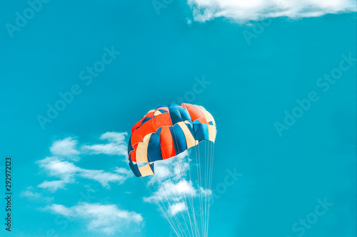 A multi-colored dome of a parachute in the sky as a background.