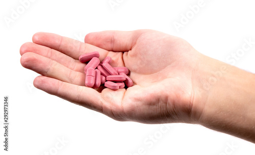 Red pills in man`s hand isolated on white background