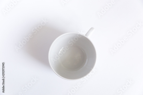 Empty white tea cup on a white background with a shadow. Top view. 