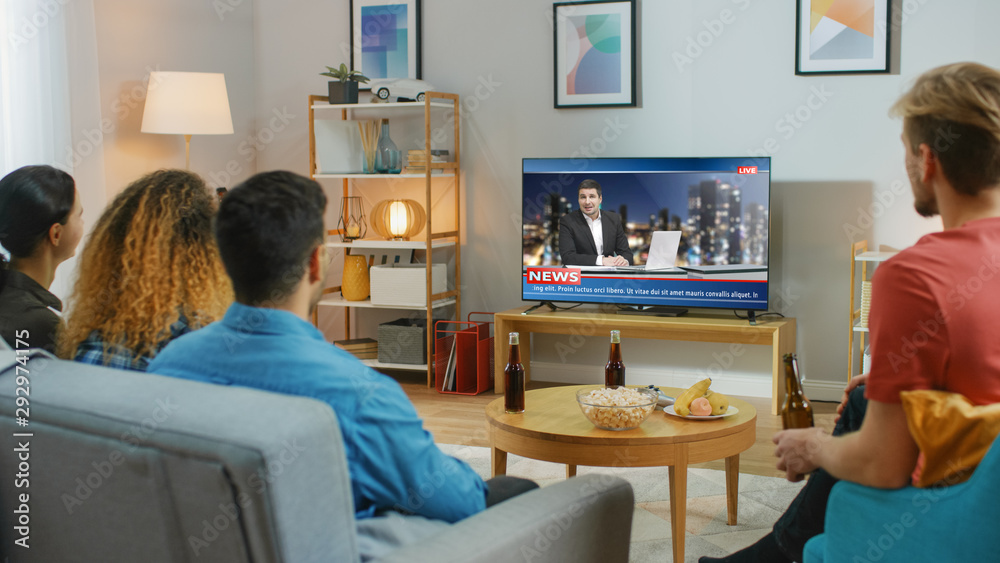 Obraz premium Happy Friends Sitting At Home Watching News. Relaxing on a Couch.right Cozy Apartment with Friends Eating Snacks and Having Fun.