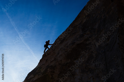 Silhouette of a mountain climber up a mountain