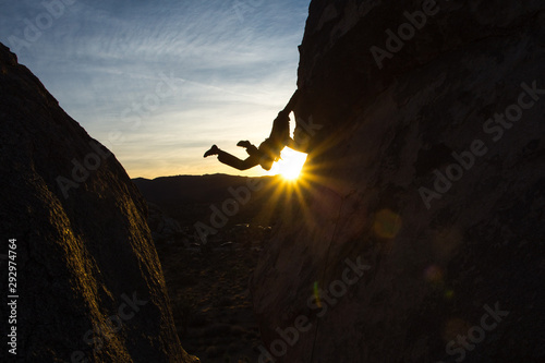 Bild auf Leinwand Silhouette of a climber with feet in the air and a starburst.