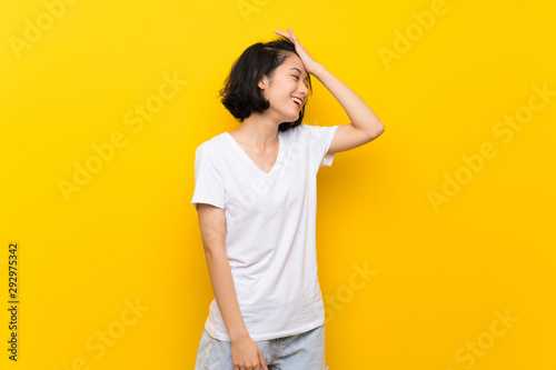 Asian young woman over isolated yellow wall has realized something and intending the solution