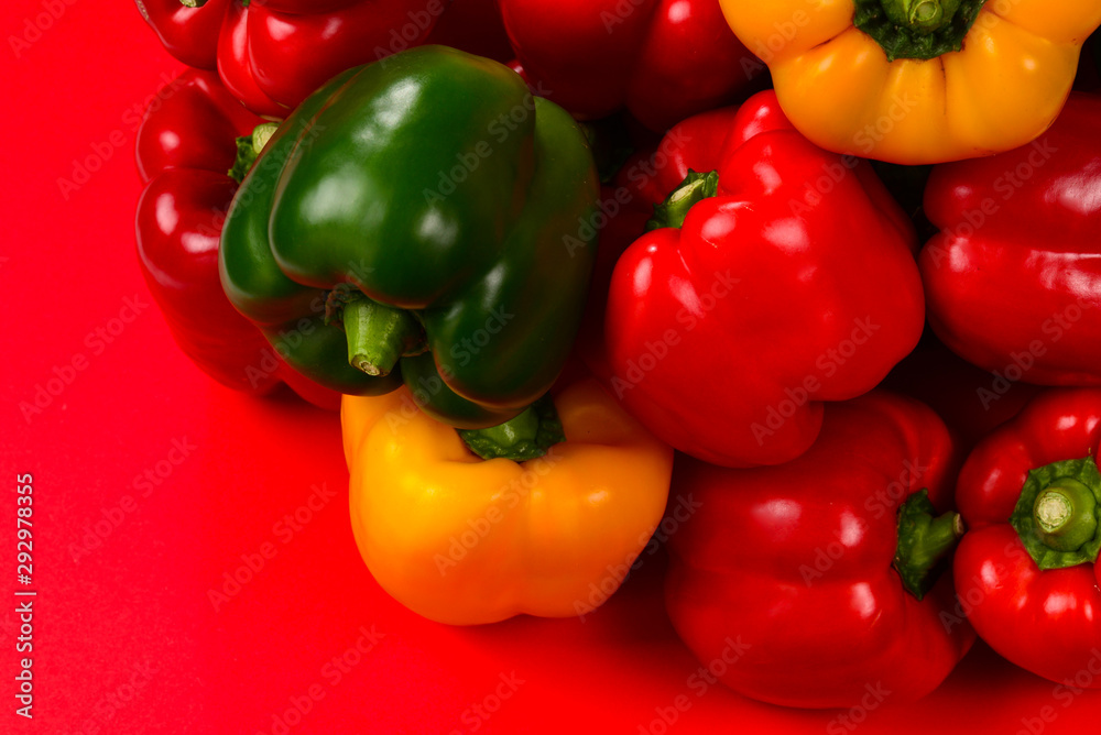 Fresh red, yelow, green bell pepper on a red background. Fresh red, yelow, green bell pepper on a red background.