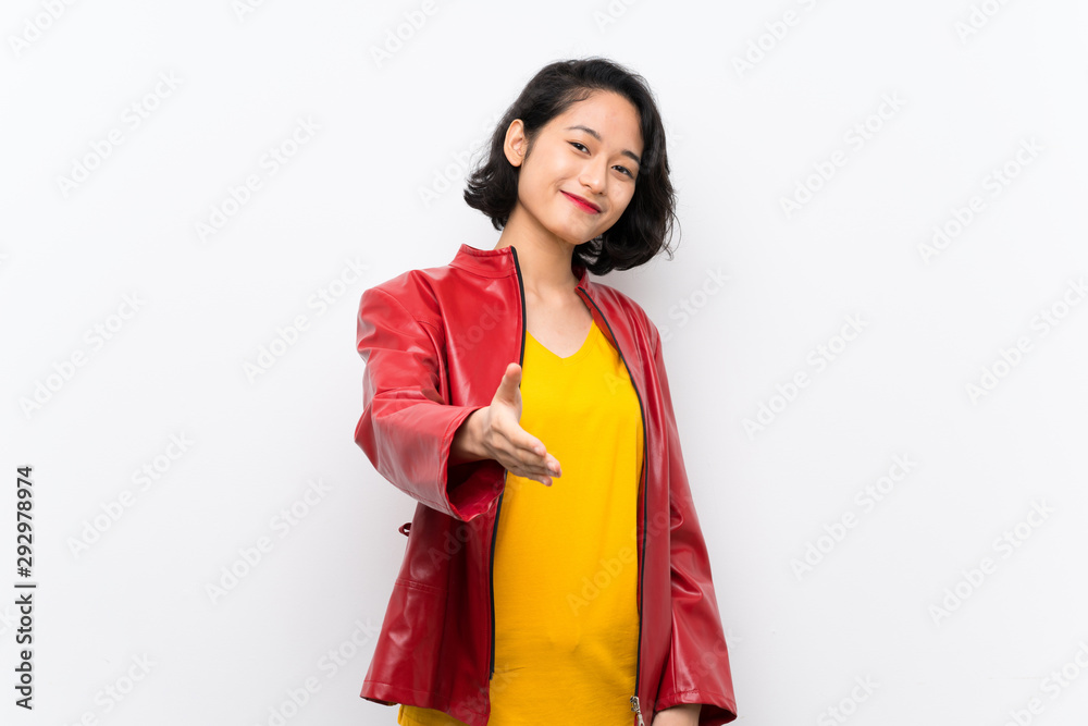Asian young woman over isolated white background shaking hands for closing a good deal Asian young woman over isolated white background shaking hands for closing a good deal
