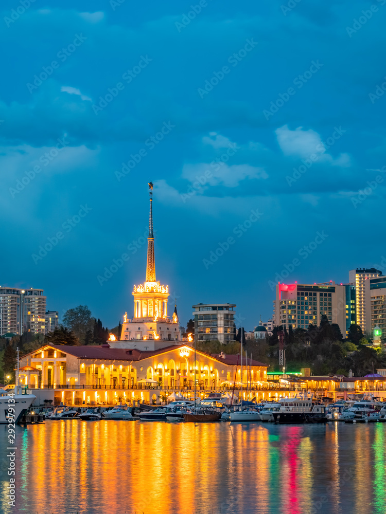 Obraz premium Marine Station of Sochi, illuminated with lights at evening with reflection in water
