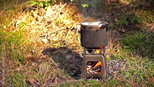 Pot boiling on wood burning twig stove outdoors