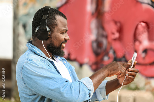 Handsome African-American man listening to music outdoors
