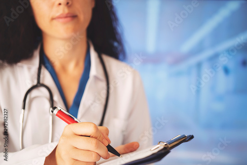 Woman doctor writes notes on the clipboard in the hospital © batuhan toker